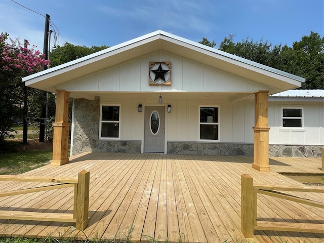 view of front of home featuring stone siding and metal roof