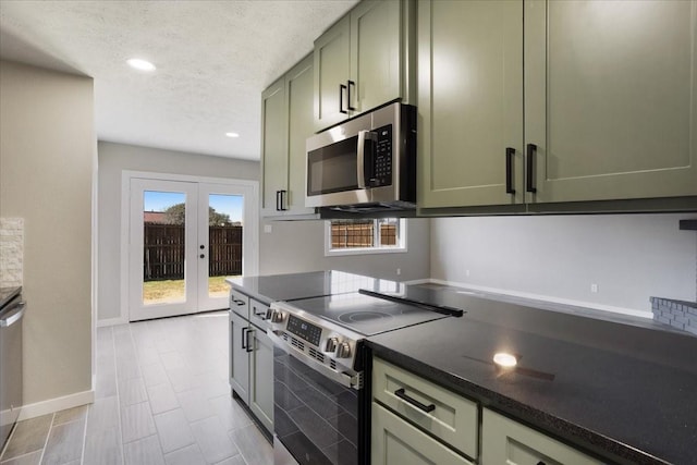 kitchen with a textured ceiling, baseboards, french doors, appliances with stainless steel finishes, and green cabinetry