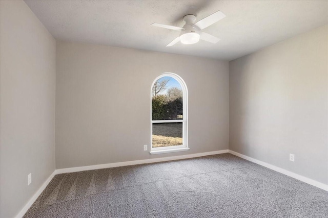 spare room featuring carpet floors, baseboards, and a ceiling fan