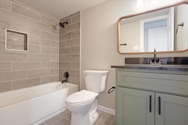 full bathroom featuring baseboards, a textured wall, toilet, bathing tub / shower combination, and vanity