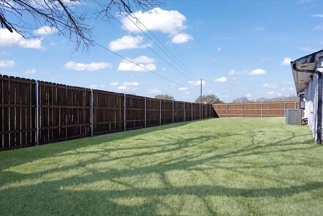 view of yard with a fenced backyard and central AC