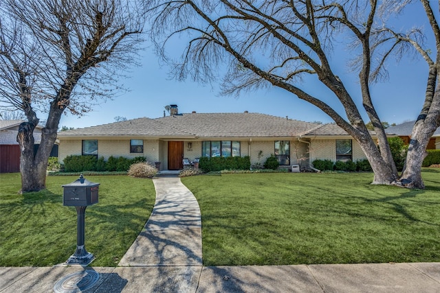 single story home with a front lawn and brick siding