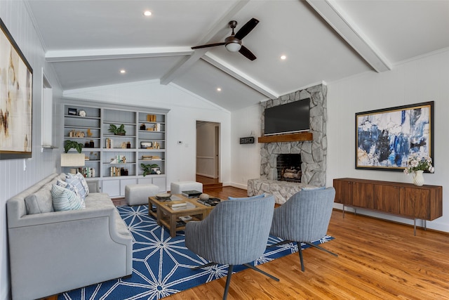 living room featuring lofted ceiling with beams, ceiling fan, a fireplace, and wood finished floors