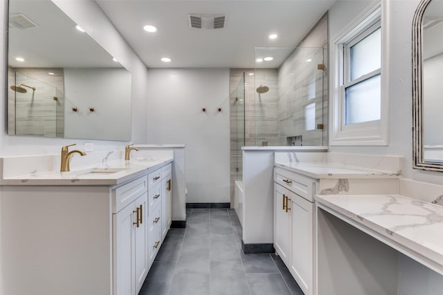 bathroom with double vanity, visible vents, a sink, and tiled shower