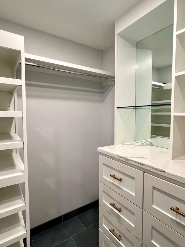 spacious closet with dark tile patterned floors