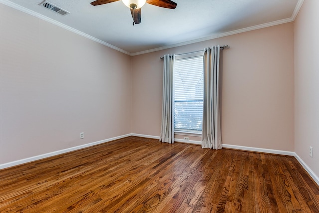 spare room featuring ornamental molding, visible vents, baseboards, and wood finished floors