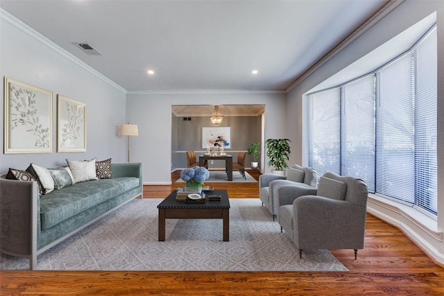 living room featuring recessed lighting, visible vents, wood finished floors, and ornamental molding