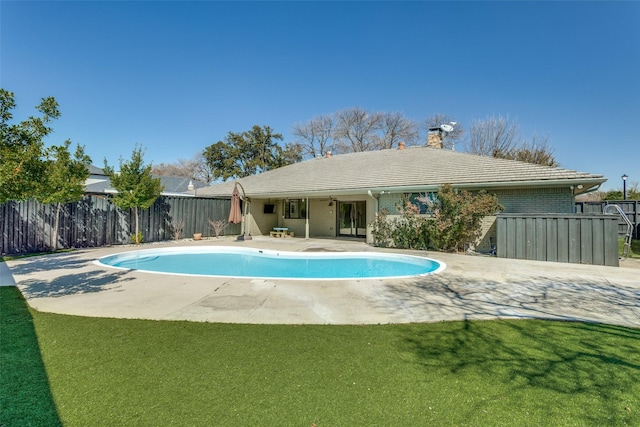 view of pool with a fenced in pool, a patio area, fence, and a lawn