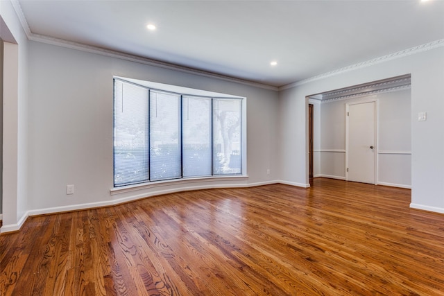 spare room with ornamental molding, recessed lighting, wood finished floors, and baseboards