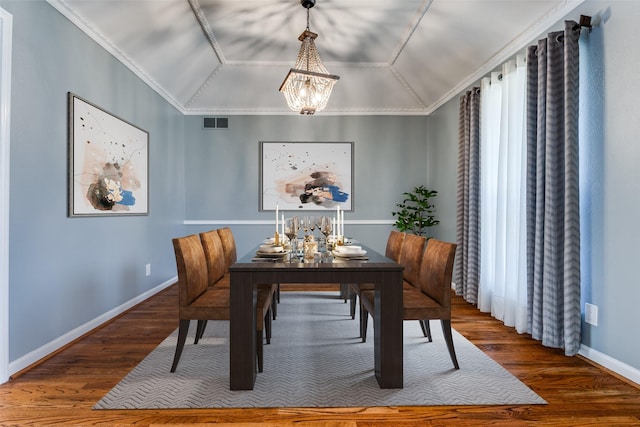 dining space with lofted ceiling, visible vents, an inviting chandelier, wood finished floors, and baseboards