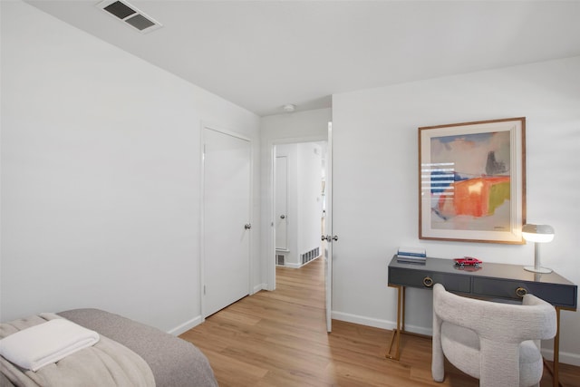 bedroom with light wood-style flooring, visible vents, and baseboards