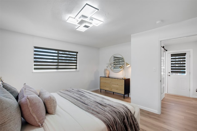 bedroom with light wood-type flooring and baseboards