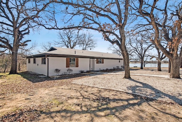 rear view of property with brick siding and a water view