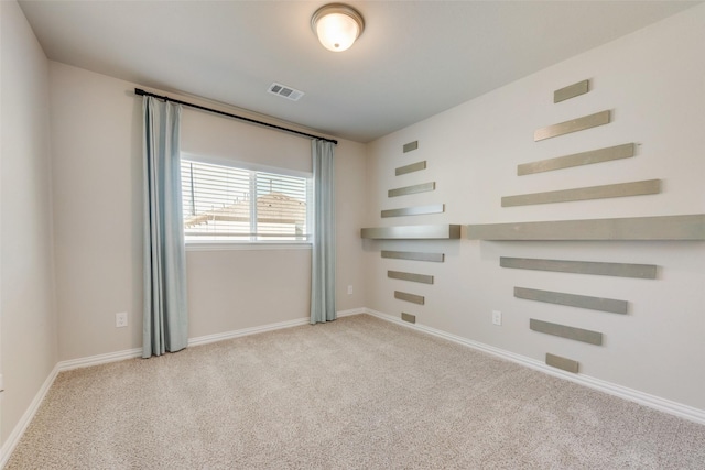 unfurnished room featuring carpet, visible vents, and baseboards