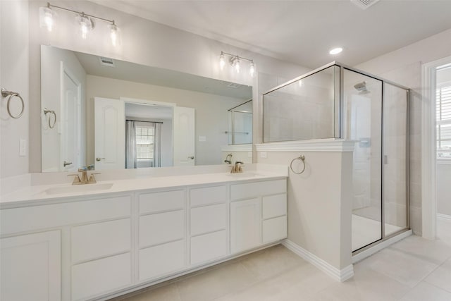 full bath featuring double vanity, tile patterned flooring, a sink, and a shower stall