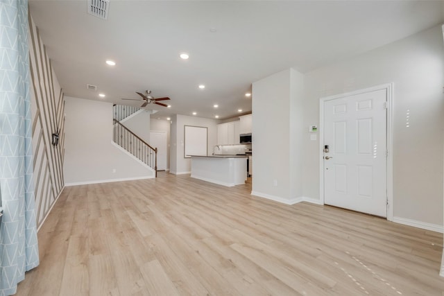 unfurnished living room with recessed lighting, visible vents, stairway, and light wood finished floors