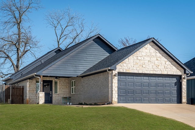 view of front facade featuring a garage, driveway, a front lawn, and stone siding