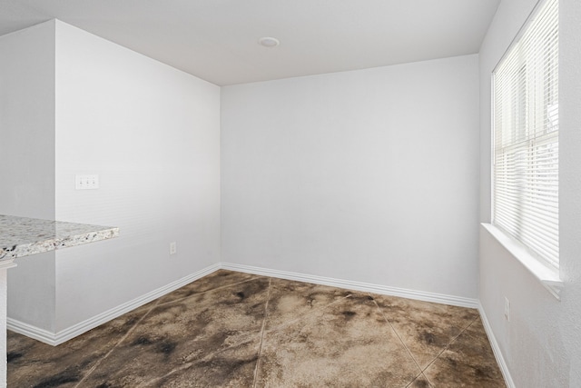 unfurnished room with baseboards