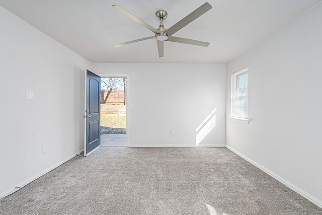 carpeted empty room with a ceiling fan and baseboards