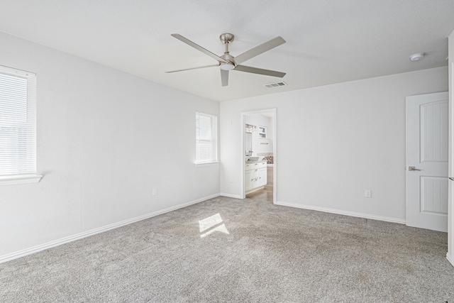 unfurnished bedroom with carpet, visible vents, ensuite bath, and baseboards