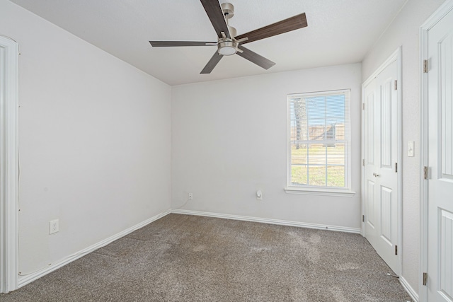 spare room with carpet flooring, ceiling fan, and baseboards