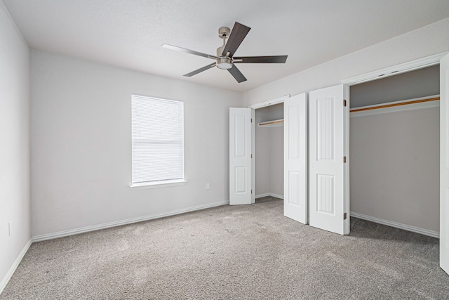 unfurnished bedroom featuring ceiling fan, multiple closets, carpet, and baseboards