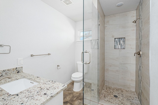 full bath with visible vents, baseboards, toilet, vanity, and a shower stall