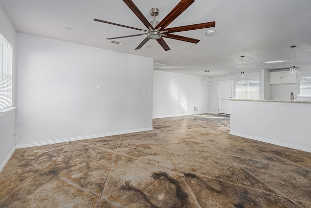 spare room with a sink, baseboards, visible vents, and a ceiling fan