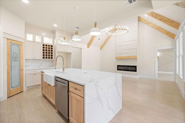 kitchen featuring visible vents, a sink, beamed ceiling, and dishwasher