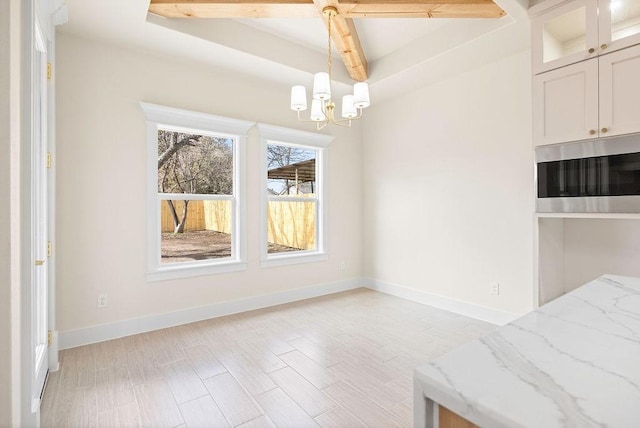 unfurnished dining area with light wood-type flooring, baseboards, and an inviting chandelier