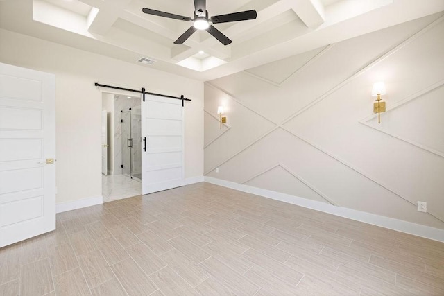 unfurnished room with visible vents, a barn door, a ceiling fan, wood tiled floor, and baseboards