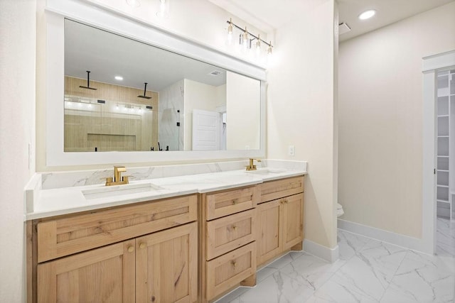 full bath with double vanity, baseboards, marble finish floor, a shower stall, and a sink