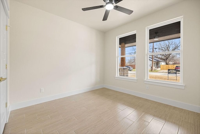 unfurnished room with a ceiling fan, light wood-type flooring, and baseboards