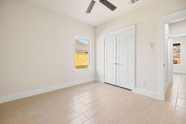 unfurnished bedroom with ceiling fan, light wood-style flooring, visible vents, baseboards, and a closet