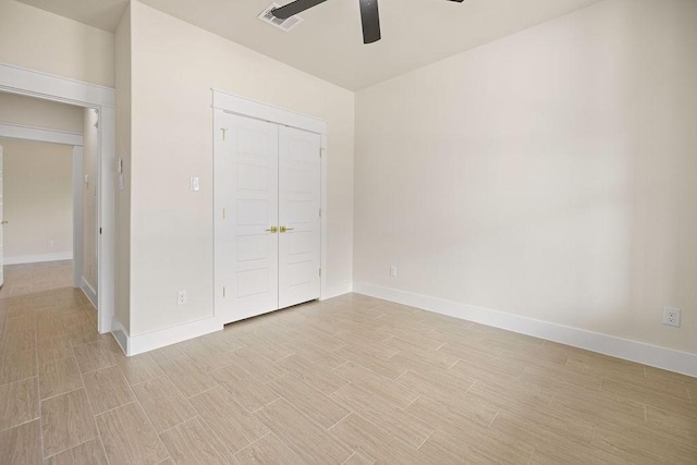 unfurnished bedroom with a closet, visible vents, a ceiling fan, wood tiled floor, and baseboards