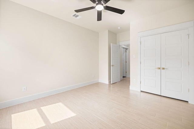 unfurnished bedroom with light wood finished floors, visible vents, baseboards, a ceiling fan, and a closet