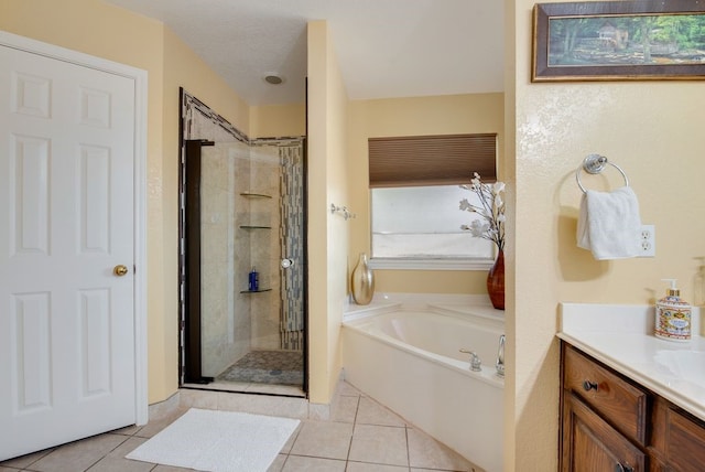 bathroom featuring a stall shower, tile patterned flooring, a textured ceiling, vanity, and a bath