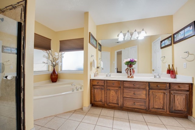 full bath featuring a shower, a garden tub, double vanity, a sink, and tile patterned flooring