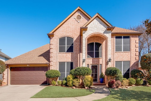 view of front facade with a garage, driveway, a shingled roof, stone siding, and brick siding