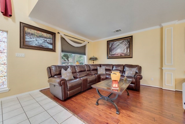 living area with ornamental molding, visible vents, light wood-style floors, and baseboards