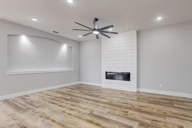 unfurnished living room with a large fireplace, baseboards, a ceiling fan, wood finished floors, and recessed lighting