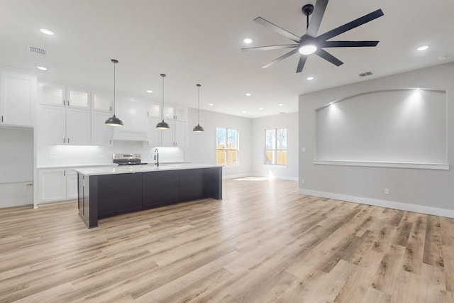 kitchen featuring visible vents, white cabinets, open floor plan, light countertops, and stainless steel electric stove