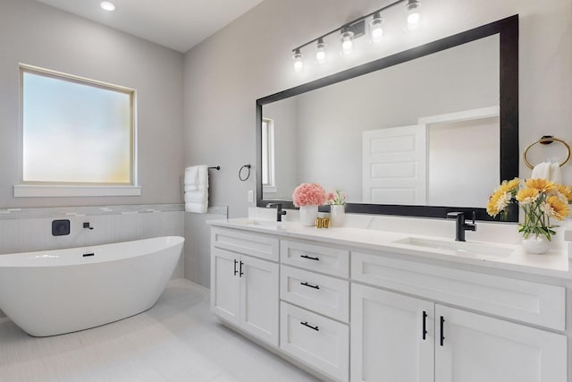 full bath with double vanity, a soaking tub, and a sink