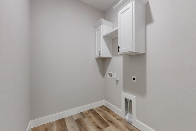 laundry area with cabinet space, light wood finished floors, baseboards, hookup for a washing machine, and electric dryer hookup