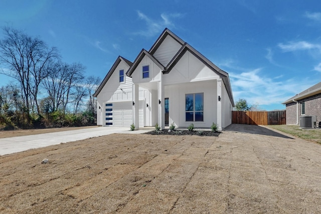 modern farmhouse featuring central AC unit, board and batten siding, fence, a garage, and driveway