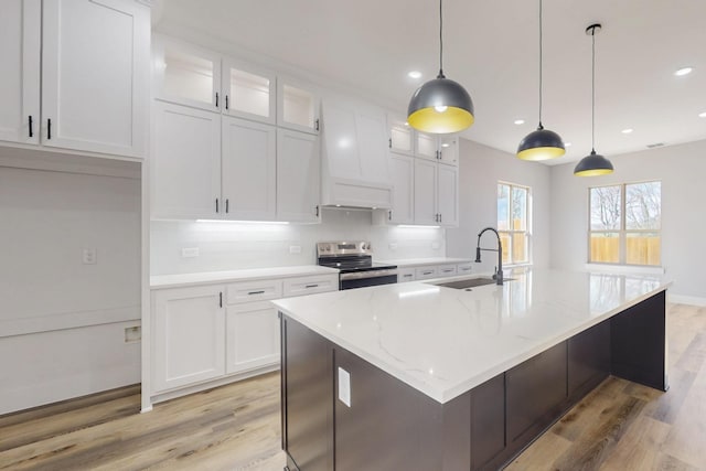 kitchen featuring light wood-type flooring, white cabinets, a sink, and stainless steel electric range