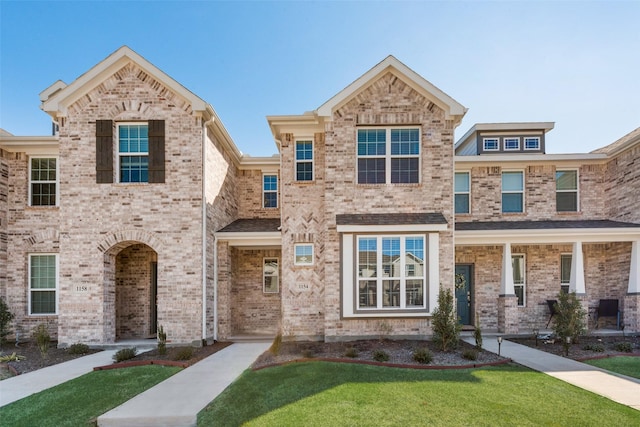 view of front of home with a front yard and brick siding