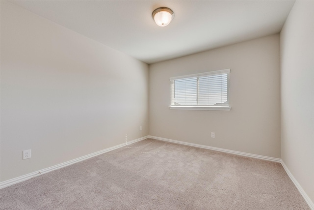 unfurnished room featuring light colored carpet and baseboards