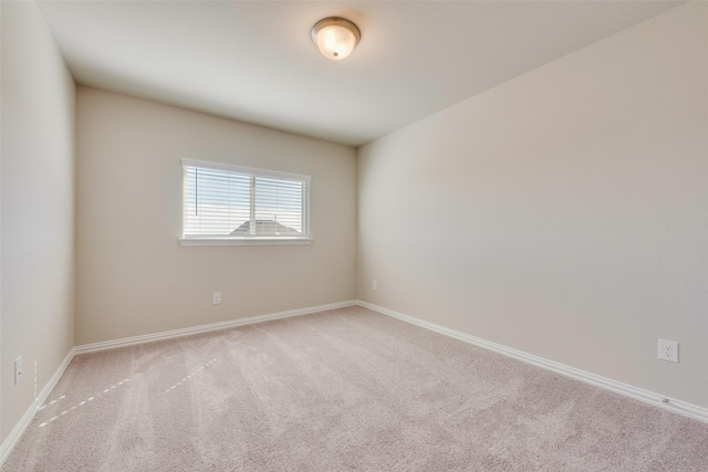 carpeted empty room with baseboards