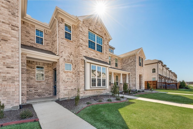 view of front of house featuring a front yard and brick siding